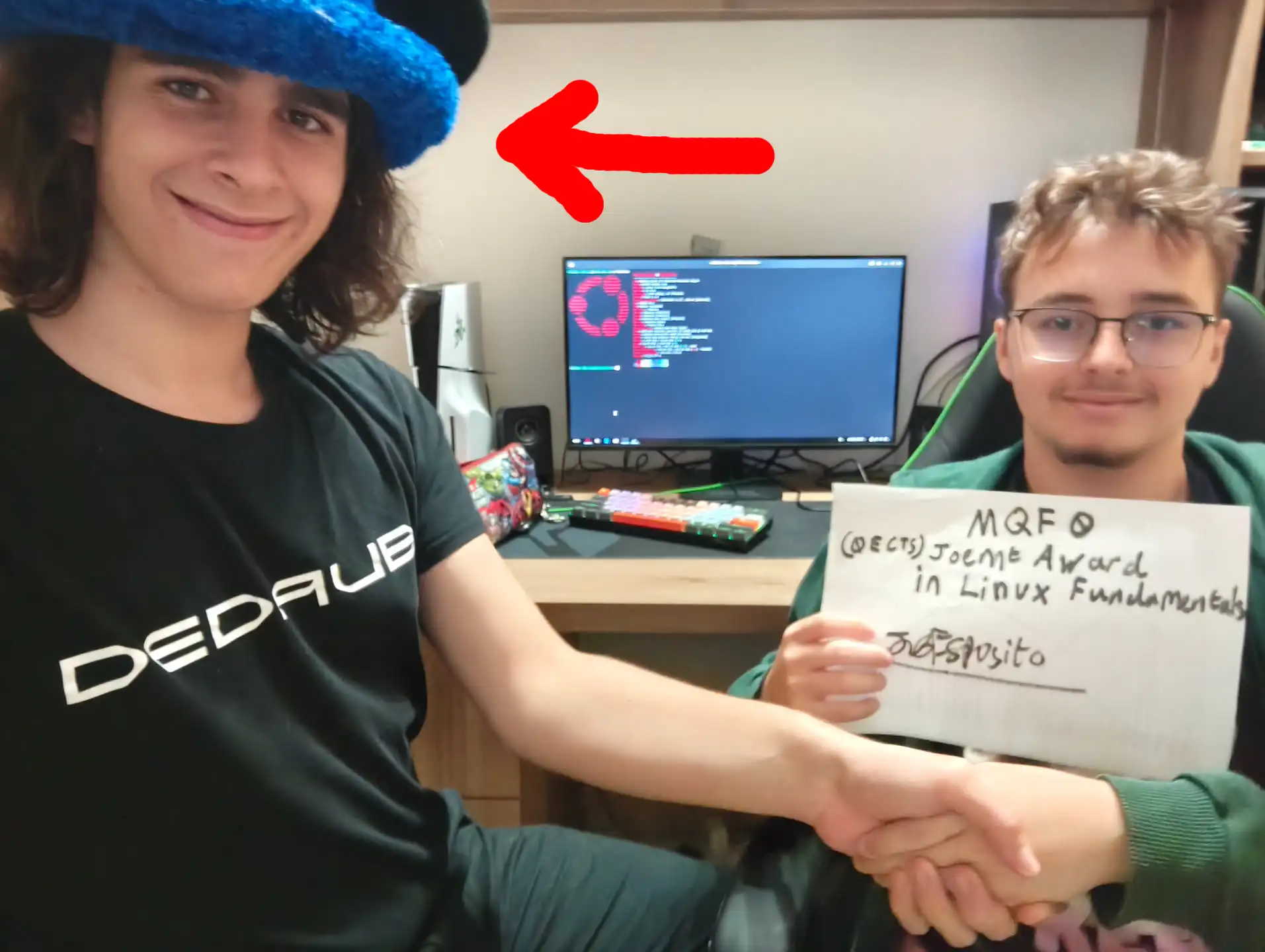 Joe posing with a friend in front of a computer